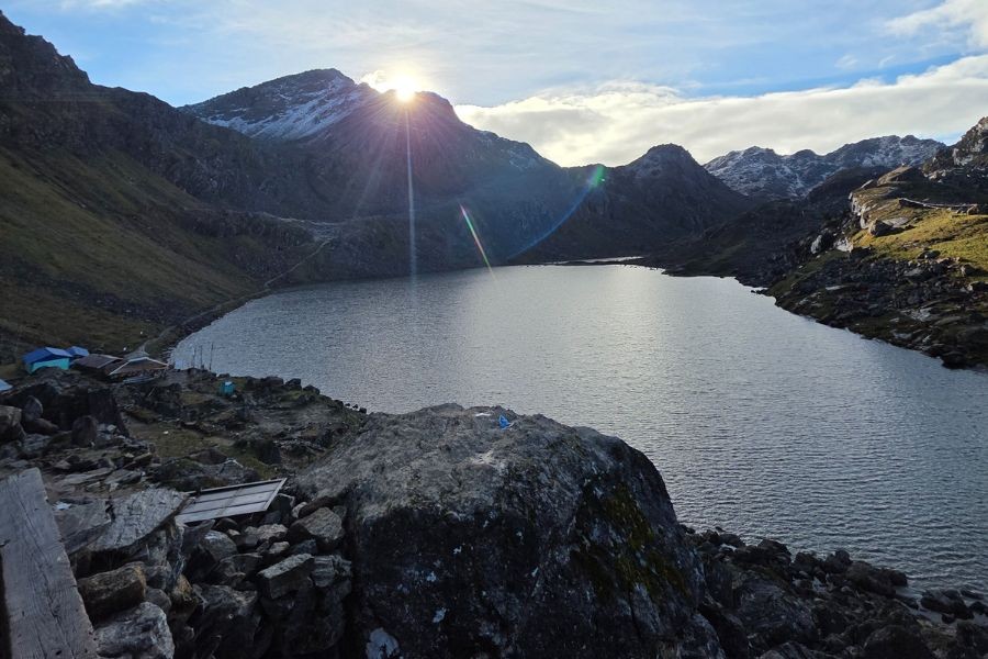 Gosaikunda Lake at sunset with prayer flags and mountain peaks